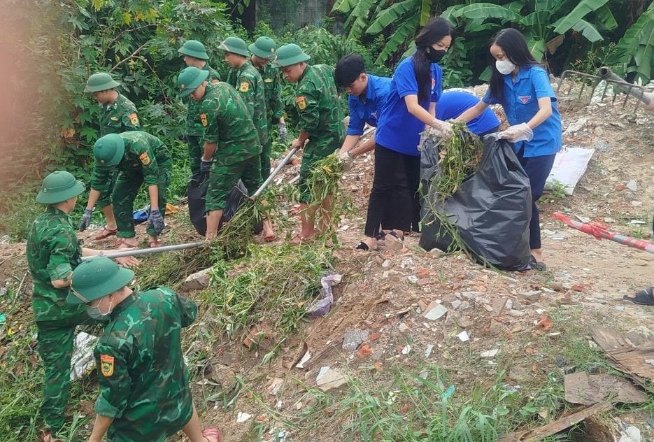 luc luong vu trang va doan vien thanh nien tren dia ban thanh pho ra quan don dep ve sinh moi truong. anh l.h
